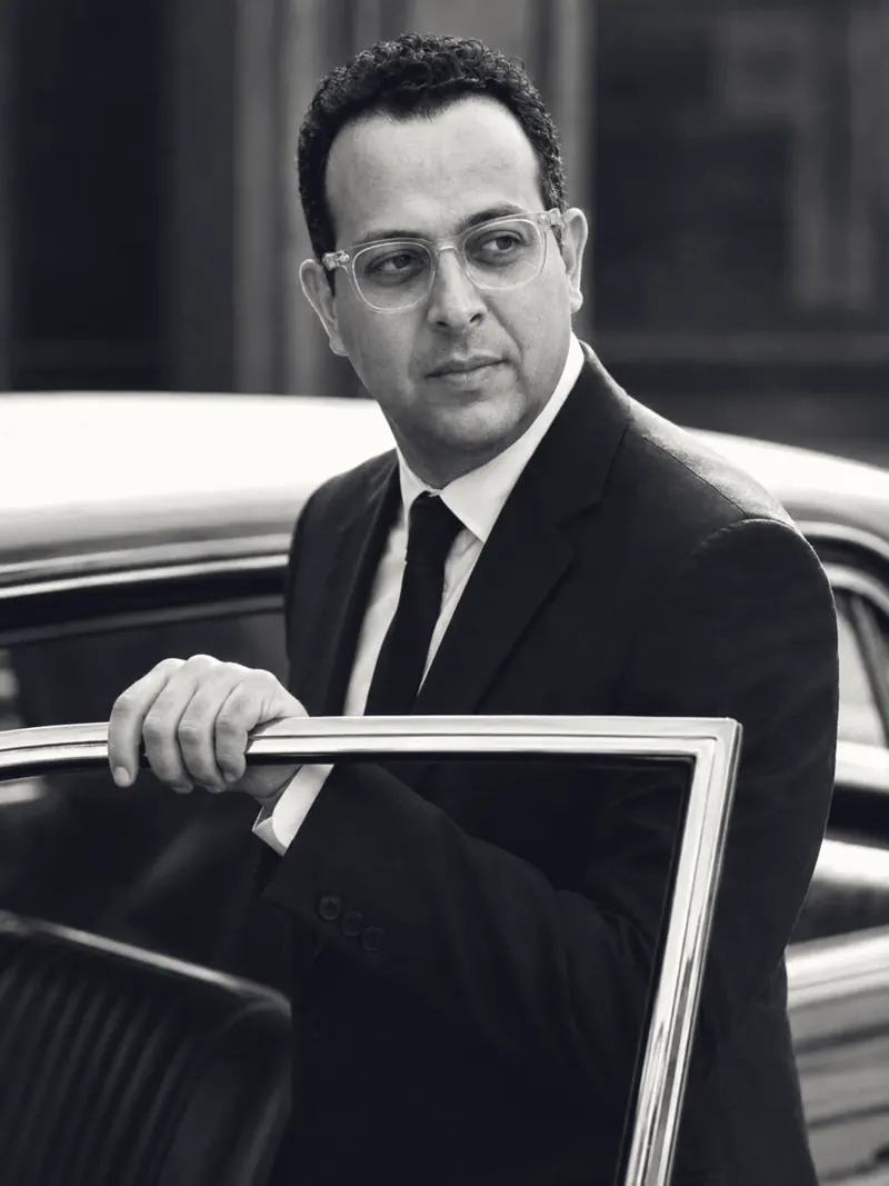 Mohamed B. Kumiha in a suit stepping out of a car